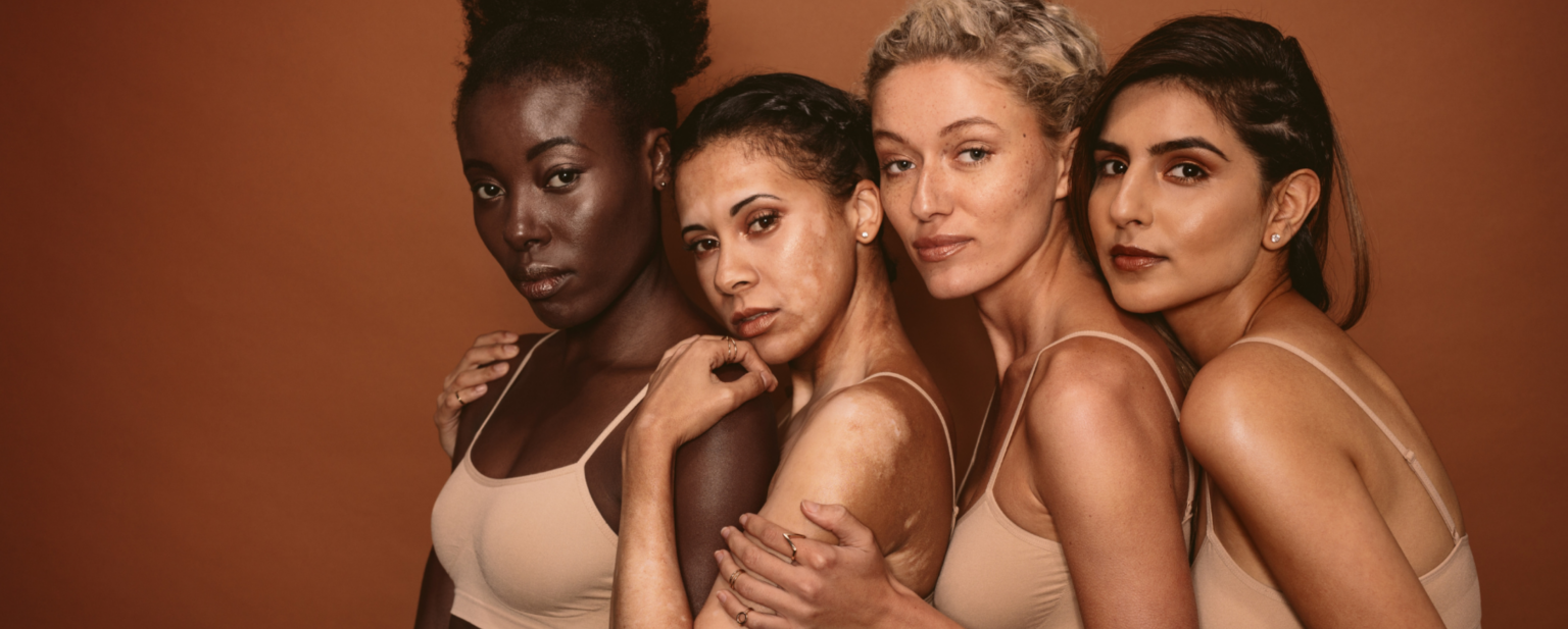 Four Girls with different types of skin, the first one dark, the second one vitiligo, than freckles, and the fourth olive skin, in brown-gold background