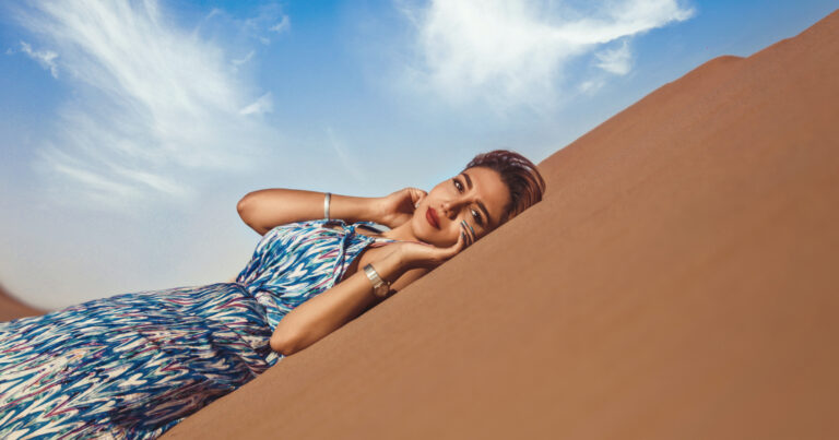 Girl laying on desert sand Halal Beauty