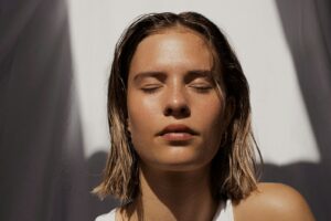 Woman with radiant, glowing skin lit by natural sunlight